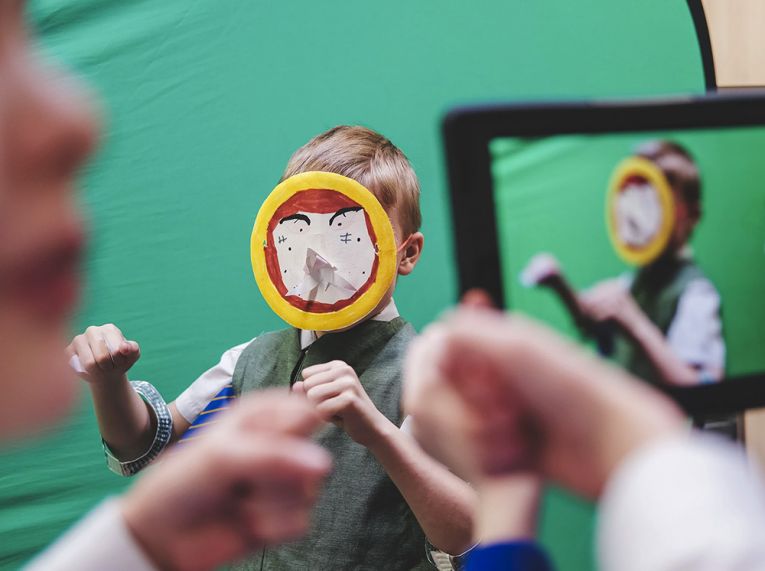 Children filming in the classroom as part of an English literacy project